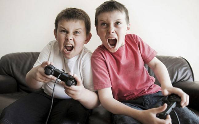 due bambini giocano ad un videogioco violento alla playstation.