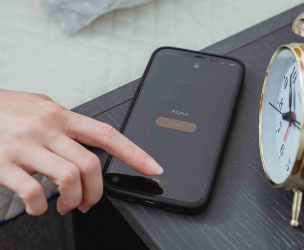 mano che spegne la sveglia sullo smartphone