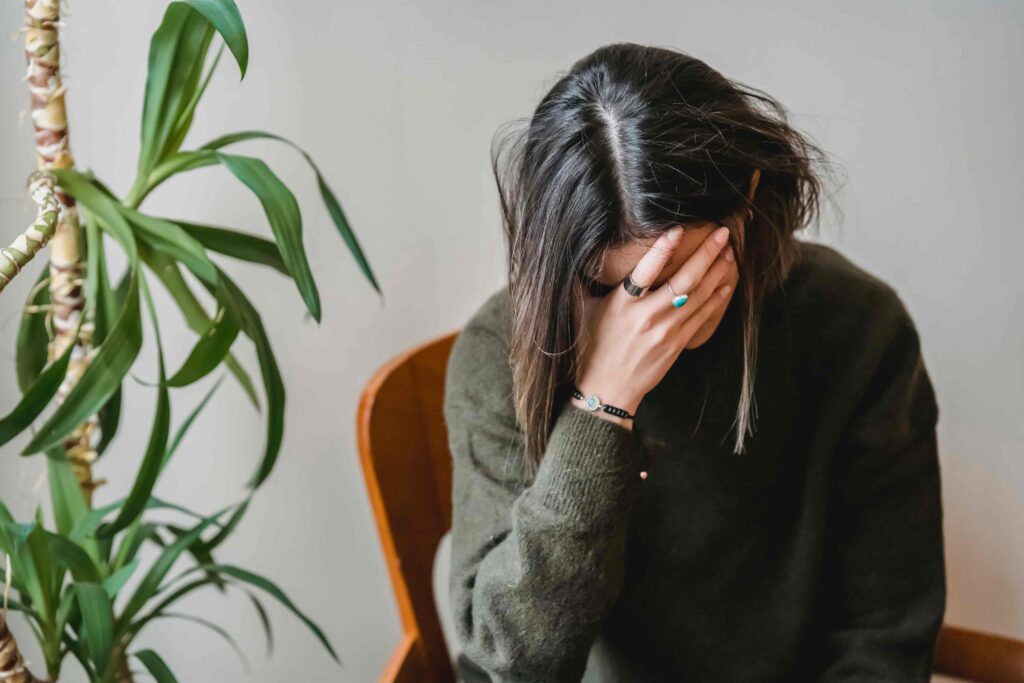 Ragazza piange con una mano sul volto perchè in preda ad un attacco di ansia