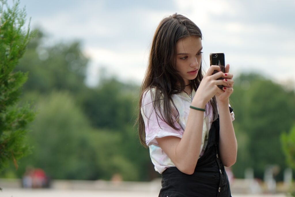 una ragazza sta al telefono. il genitore potrebbe volere staccarla dallo smartphone - 5 + 1 Strategie efficaci per staccare un figlio dal cellulare